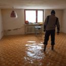 A person wades through ankle deep water in a basement